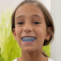 Smiling girl wearing the blue Functional Activator mewing mouth guard